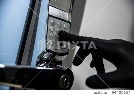 Thief in black gloves tries to enter the code 94409654