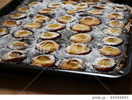 detail of poppy plum cake on baking sheet 94409665