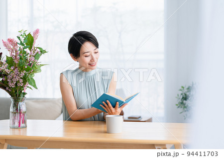 リビングで本を読むミドルの女性 94411703