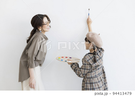 絵の具のパレットと筆を持った女の子と母親 94413479