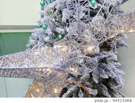 Close-up of a braided deer head on a Christmas tree background. The branches are covered with frost. Christmas or New Year background 94415068