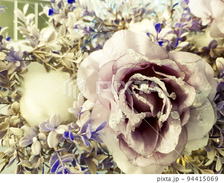 Frozen rose in white frost. Rose petals in small ice crystals surrounding a flower, decorative decoration of a Christmas tree, selective focus 94415069