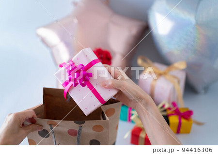 ペーパーバックからプレゼントを取り出す女性 94416306