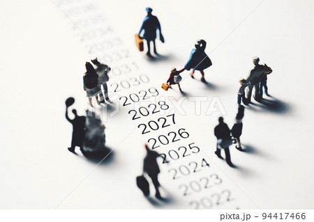 年表の横を歩くミニチュアの人々 94417466