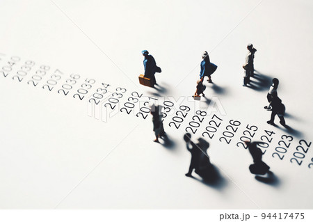 年表の横を歩くミニチュアの人々 94417475