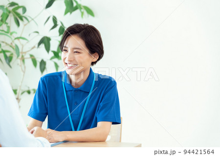 利用者の話を聞くケアマネージャー 94421564