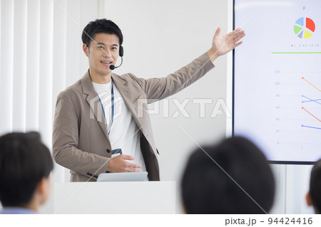 セミナー　登壇者　ヘッドマイクを付けて話す男性 94424416