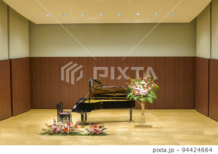 舞台上で演奏者の登場を待つグランドピアノ 94424664