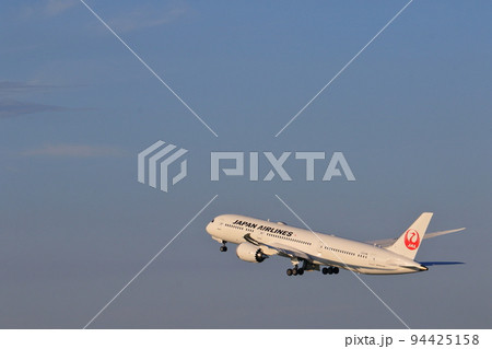 夕日を浴びて離陸する旅客機　 94425158