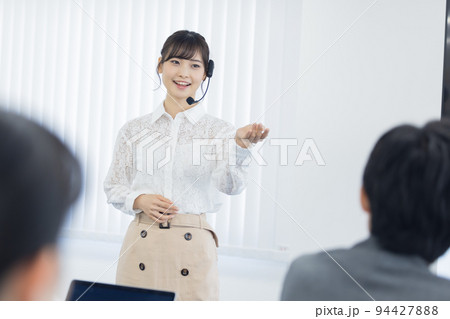 セミナー　ヘッドマイクを付けて話す女性 94427888