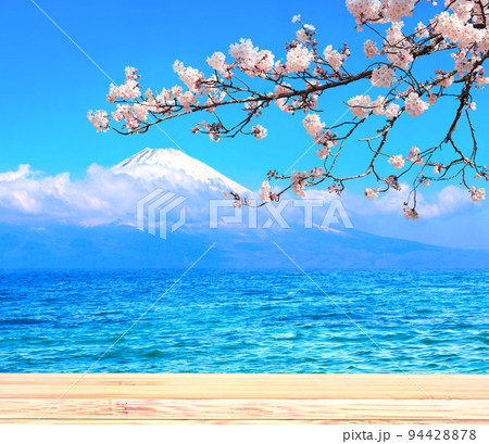 Sacred Mount Fuji, blooming sakura branch, lake and old wooden plank, Japan. Empty wooden table top and scenic with Fujiyama volcano Sacred Mount Fuji, blooming sakura branch, lake and old wooden plank, Japan. Empty wooden table top and scenic with Fujiyama volcano 94428878