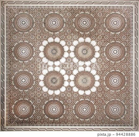 Ancient carved floral ornament in the Moroccan style. Square bas-relief with decorative element in arabic style 94428886