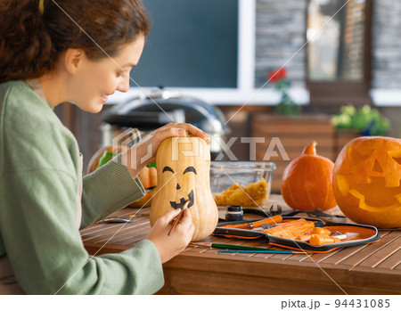woman is carving pumpkins 94431085