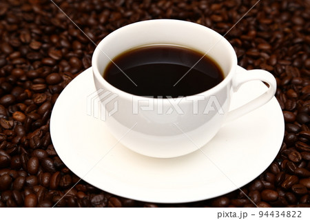 コーヒー豆に浮かぶ白いカップに入ったホットコーヒー コーヒー豆に浮かぶ白いカップに入ったホットコーヒー 94434822