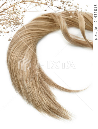A strand of blond hair on a white background. Close-up. A strand of blond hair on a white background. Close-up. 94435818
