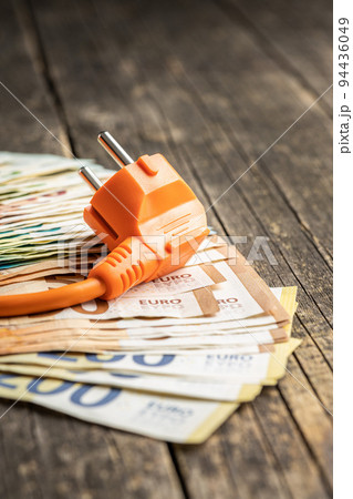 Electric plug and euro money on wooden table. Concept of increasing electric prices. Electric plug and euro money on wooden table. Concept of increasing electric prices. 94436049