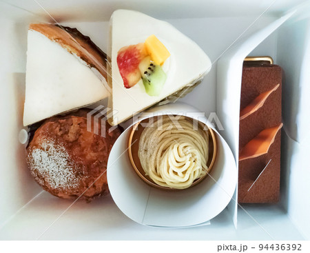 お土産のケーキの箱を開ける 94436392
