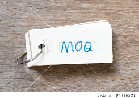 Flash card with handwriting in word MOQ (Abbreviation of Minimum Order Quantity) on wood background 94436501