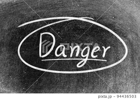 White chalk hand writing in word danger on blackboard background 94436503