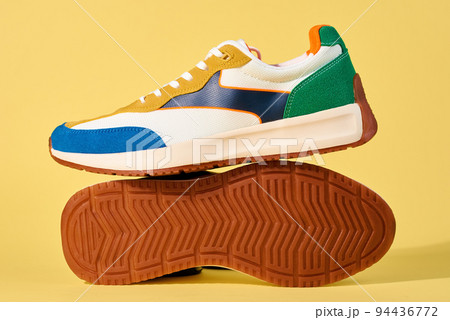 Pair of trendy shoes on yellow background. Sport sneakers with copy space, Summer footwear concept Pair of trendy shoes on yellow background. Sport sneakers with copy space, Summer footwear concept 94436772