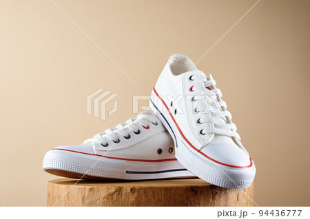 Pair of trendy shoes on beige background. Sport sneakers with copy space, Summer footwear concept 94436777