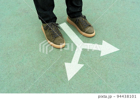 Feet and two arrows painted on blue surface Feet and two arrows painted on blue surface 94438101