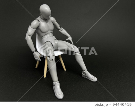 疲れ果てて椅子にぐったりと座るデッサン人形 94440419