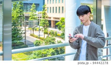 オフィスカジュアルのスマホを操作する若いビジネスマン 新橋駅前 オフィスカジュアルのスマホを操作する若いビジネスマン 新橋駅前 94442278