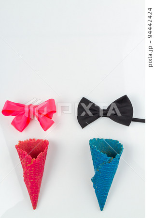 Vertical shot pink and blue ice cream waffle cones. Bow ties on white background. 94442424