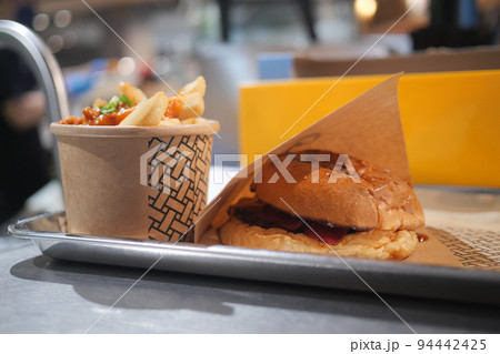 junk foods on plate on wooden table close up  94442425