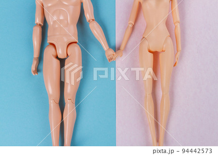 Top view naked doll couple holding hands. Blue and pink background. Top view naked doll couple holding hands. Blue and pink background. 94442573
