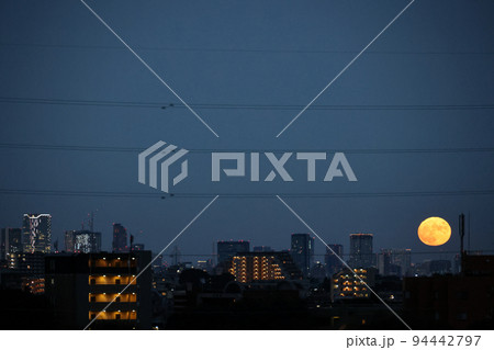 東京の街並みから登る満月 94442797
