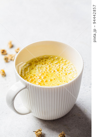 Golden turmeric chamomile moon milk in white cup. Ayurveda drink, healthy lifestyle, remedy for insomnia. 94442857