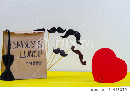 Paper bag for daddy on white background. Red heart and moustache. 94443056