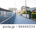 夏の夕暮れ時の道。住宅と学校のグラウンドの間の道。あえてぼかしている風景。 94444334