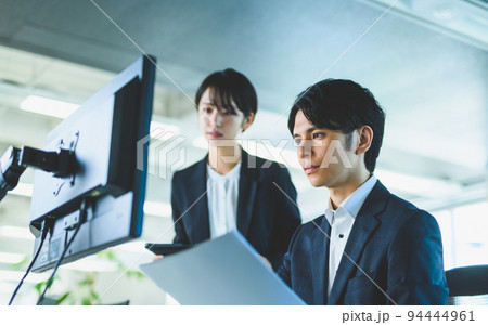 ミーティングで資料を確認するエンジニア男女 94444961