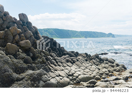 gray basalt rocks against a blurred coastal seascape gray basalt rocks against a blurred coastal seascape 94446223
