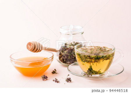 Fresh hot tea with oregano in a cup, honey in a bowl and dry herb in a jar. Herbal medicine and alternative therapy Fresh hot tea with oregano in a cup, honey in a bowl and dry herb in a jar. Herbal medicine and alternative therapy 94446518
