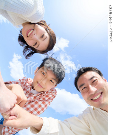 青空のもと笑顔でグータッチをする3人家族 ファミリー イメージ 青空のもと笑顔でグータッチをする3人家族 ファミリー イメージ 94446737