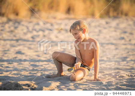 joyful kid having fun with sand on the beach joyful kid having fun with sand on the beach 94446971