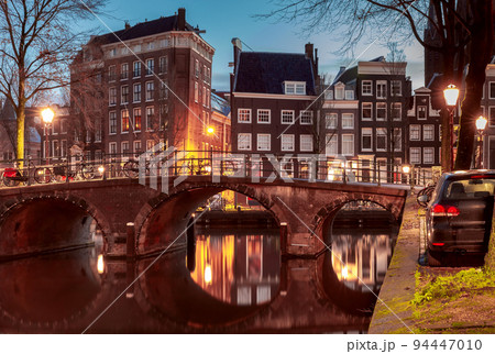 Beautiful old houses on the city waterfront of Amsterdam at sunset. 94447010