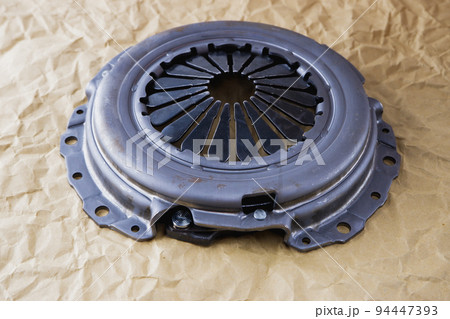 Passenger car clutch basket. Photo of a new clutch before installation on a car on a background of craft paper. 94447393