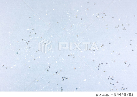 Silver glitter confetti stars on a blue background. Flat lay Silver glitter confetti stars on a blue background. Flat lay 94448783