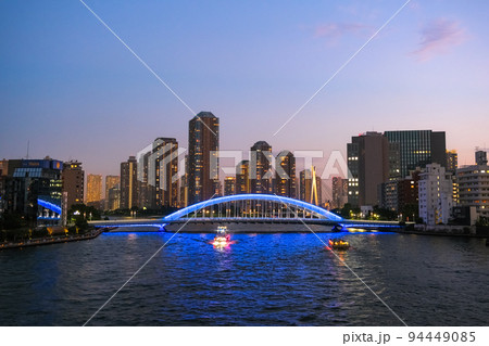東京都 夕暮れの隅田川に架かる永代橋と高層マンション群 94449085