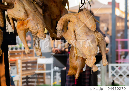 Hanging whole chickens smoking over coals at summer food market Hanging whole chickens smoking over coals at summer food market 94450270