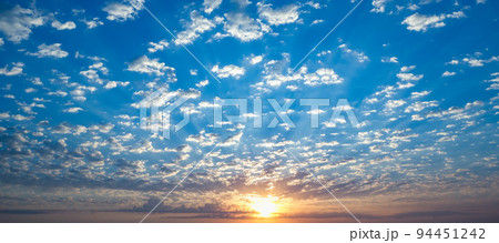 Blue sky with twilight clouds. The sun setting Blue sky with twilight clouds. The sun setting 94451242