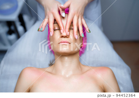 Attractive female at spa health club getting a facial massage. Beautician doing massage of face, neck and shoulders ofbeautiful young woman at luxury beauty salon 94452364