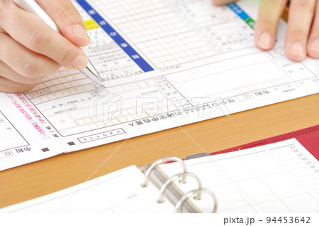 確定申告書を書く人の手元 94453642