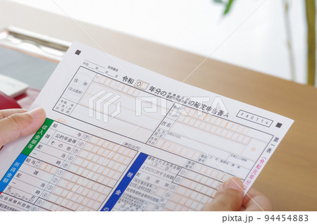 確定申告書を持つ人 94454883