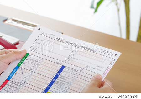 確定申告書を持つ人 94454884